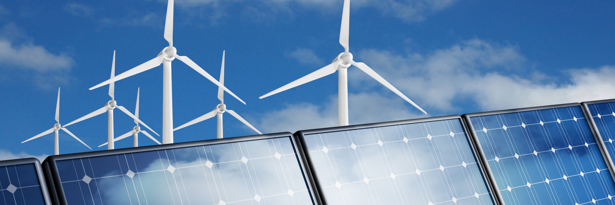 Windkraftanlagen hinter einer Reihe von Solarmodulen vor blauem Himmel